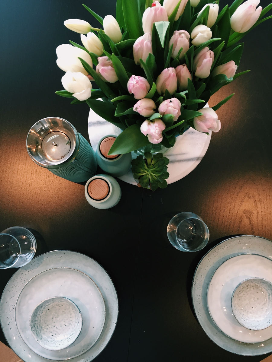 Low pink and white tulips on a dining table