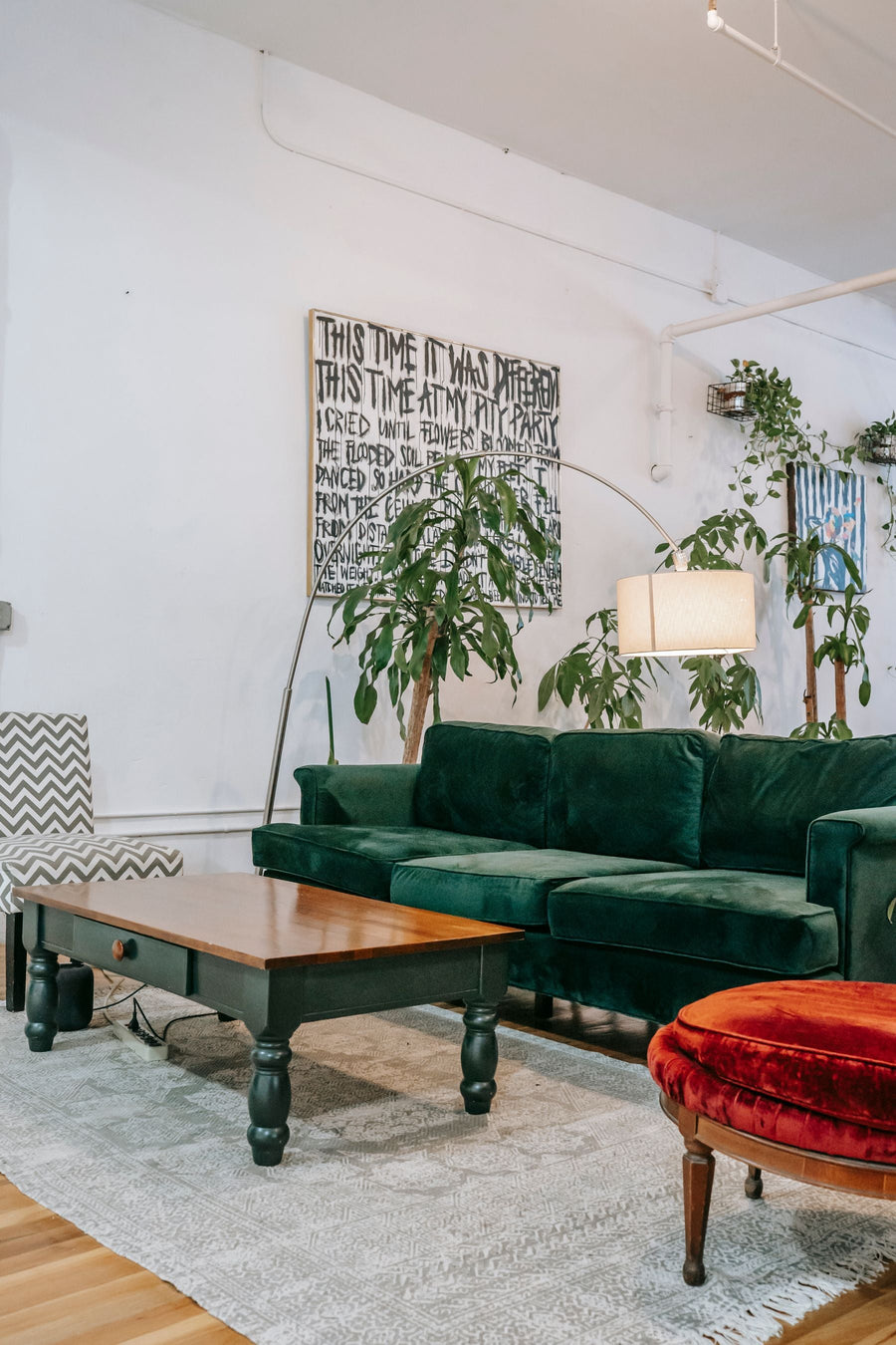 Green sofa, houseplants and natural wood in a living room
