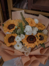 A hand-tied sunflower and white rose bouquet wrapped in natural paper; proposed Luma bouquet style. Photo: Afiqah Ct / Pexels. Reference image; final flowers and wrap subject to florist confirmation.