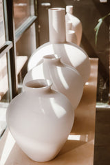White sculptural planters against a white interior wall; category inspiration only, NOT the exact Moon planter model or selected size. Photo: ROMAN ODINTSOV / Pexels.