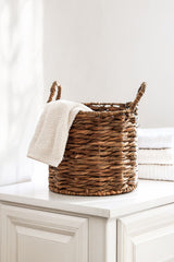 Natural woven basket in a clean white interior; materials and style reference, not the exact Sinan basket or its selected size. Photo: Kader D. Kahraman / Pexels.