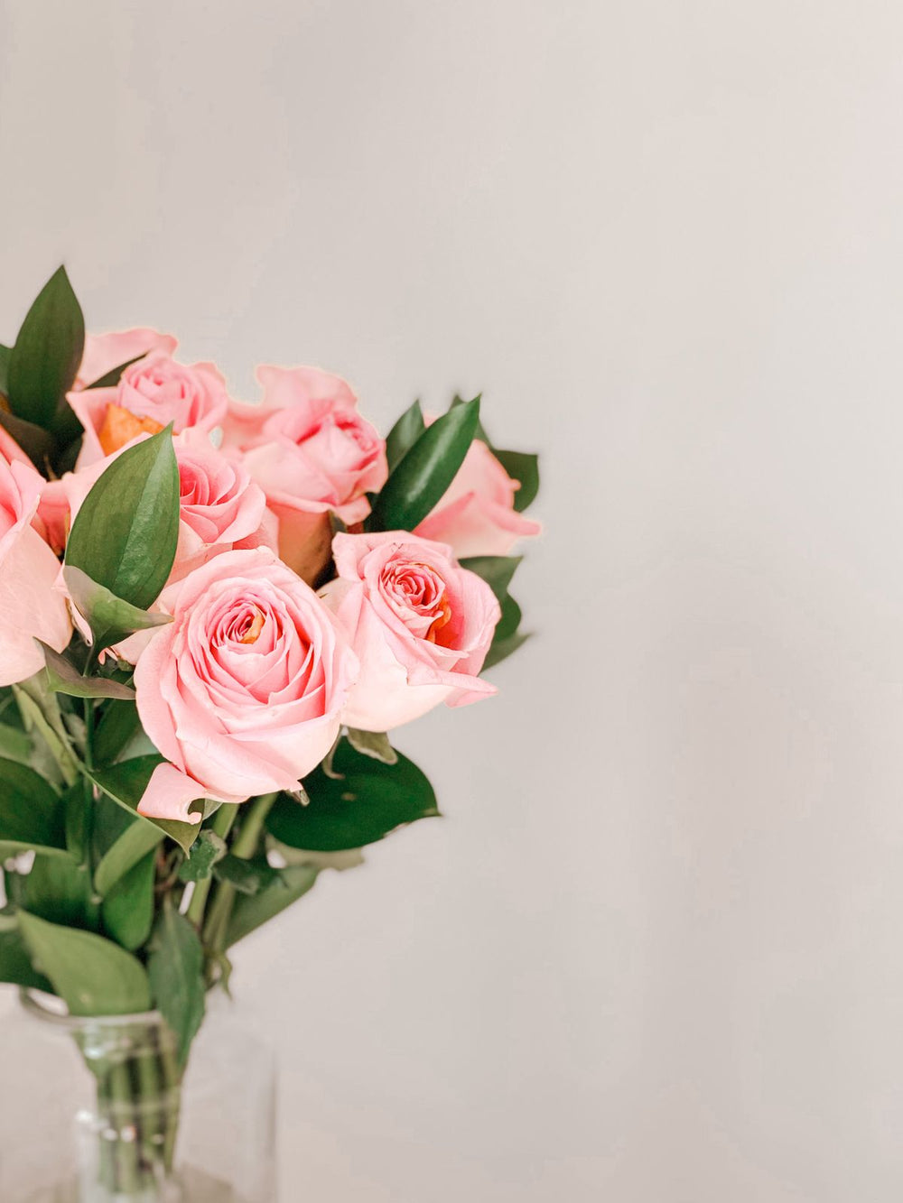Soft pink roses arranged against a white backdrop, illustrative floral palette; cream flowers and exact Luma bouquet not shown. Photo: Maram / Pexels.