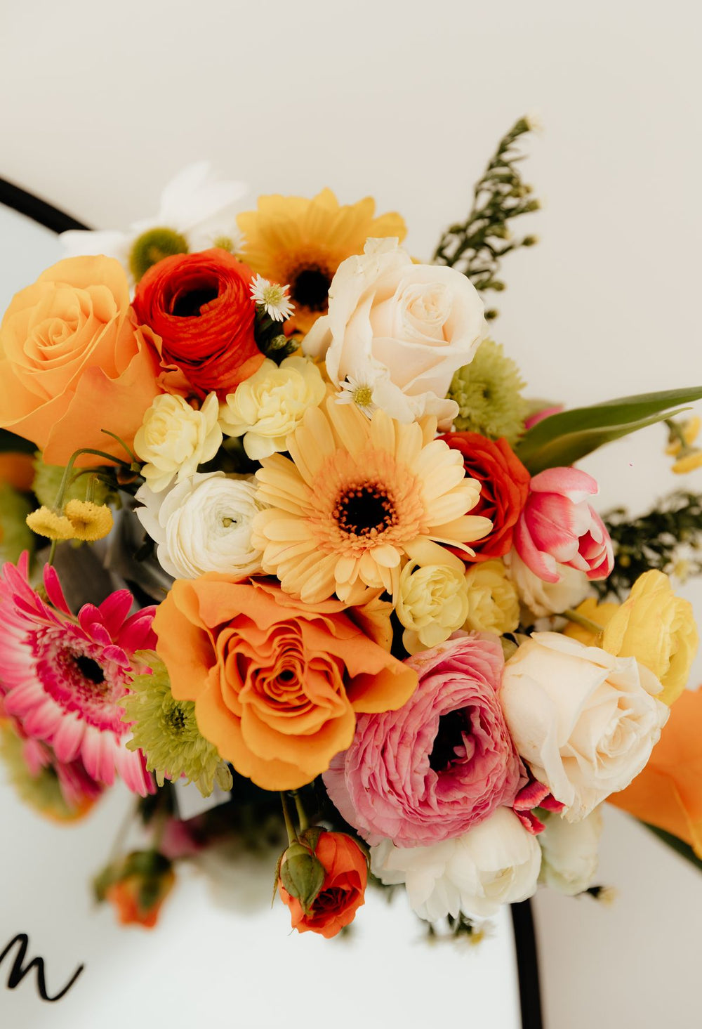 Colourful mixed flower bouquet on white; floral palette reference only, not all three completed Luma celebration bouquets. Photo: Adriana Coulson / Pexels.